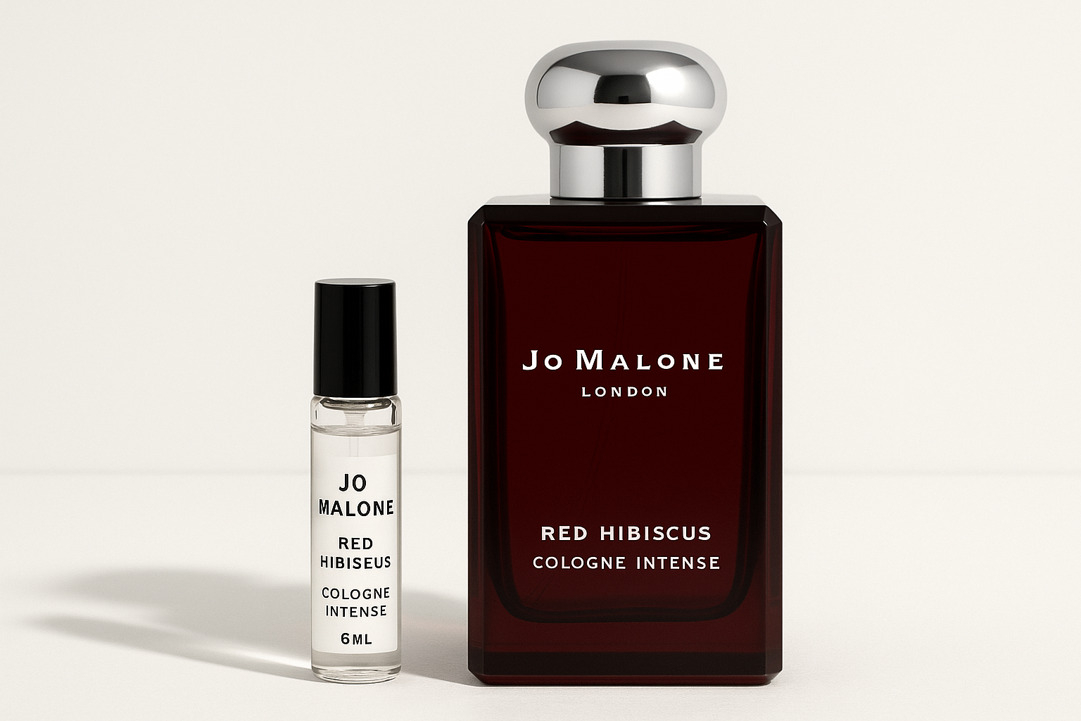 Échantillon de 6 ml de Cologne Intense Jo Malone Red Hibiscus à côté d'un flacon de parfum de 100 ml de Cologne Intense Jo Malone Red Hibiscus qui a une écriture blanche sur un flacon rouge foncé